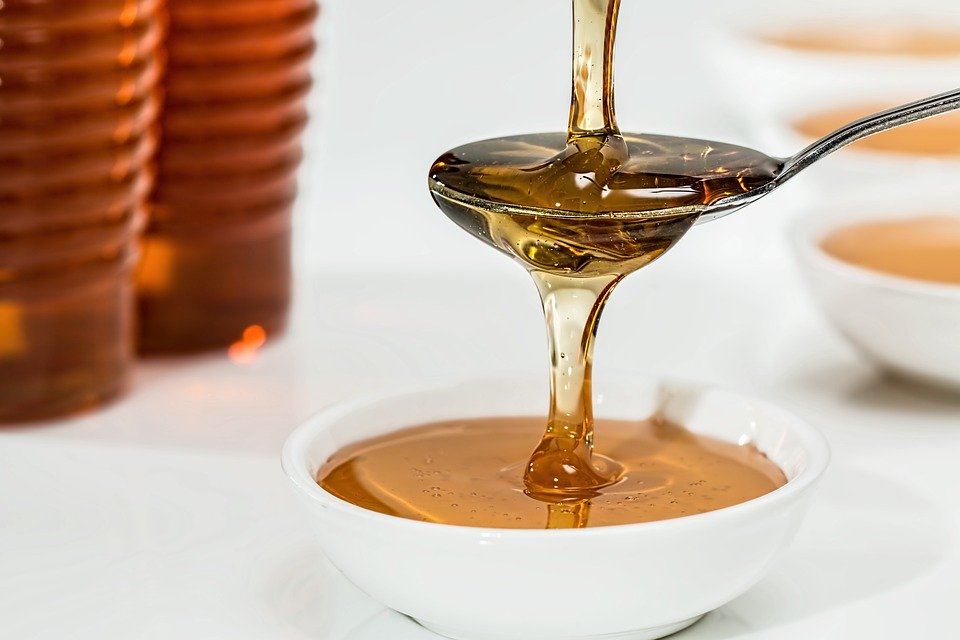 Pouring golden, organic honey into a bowlPouring golden, organic honey into a bowl