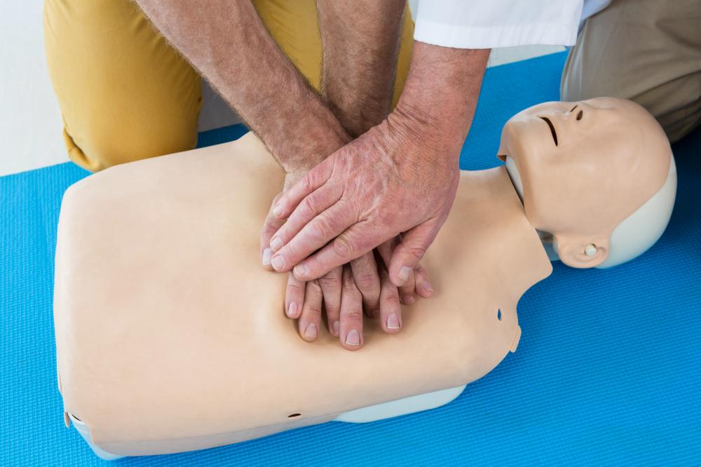 A man is practicing resuscitation on a dummy