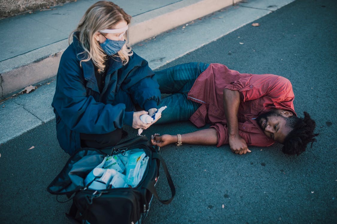 a person providing first aid to a person on the road