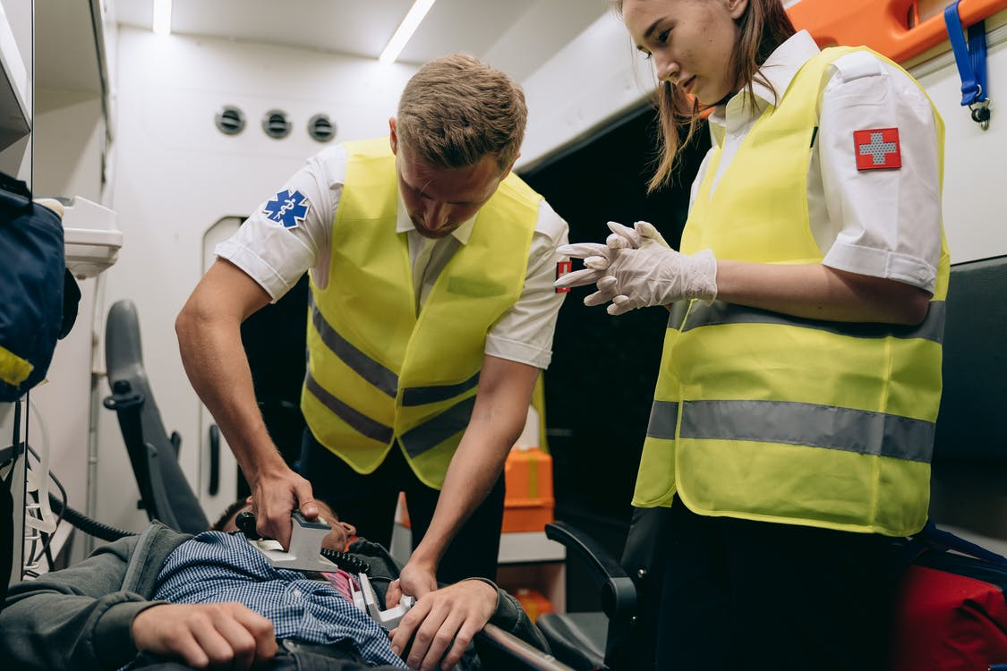 First aid workers defibrillating a patient in an ambulance