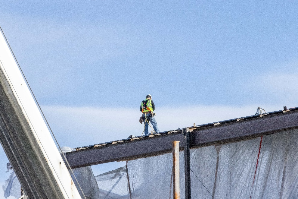 A roofer working on a rooftop of a building.