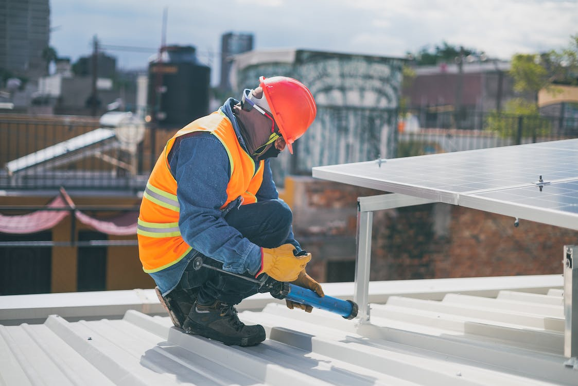 A construction worker wearing PPE while working on a roof