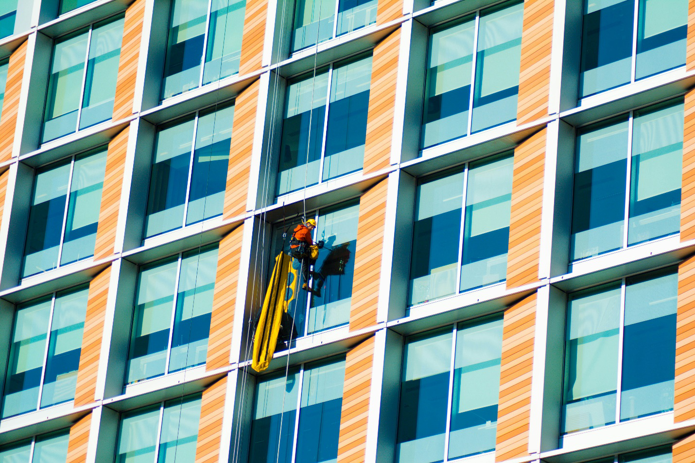 A window washer cleaning the side of a skyscraper.
