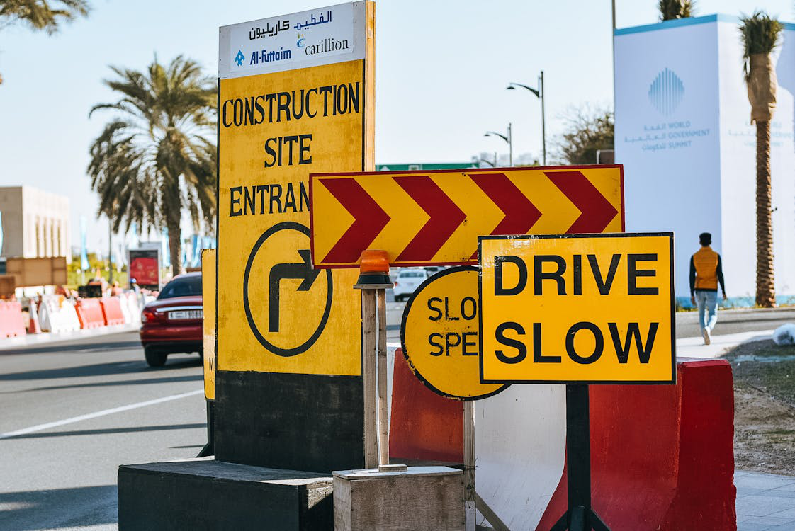 Road in modern city with yellow warning traffic signs