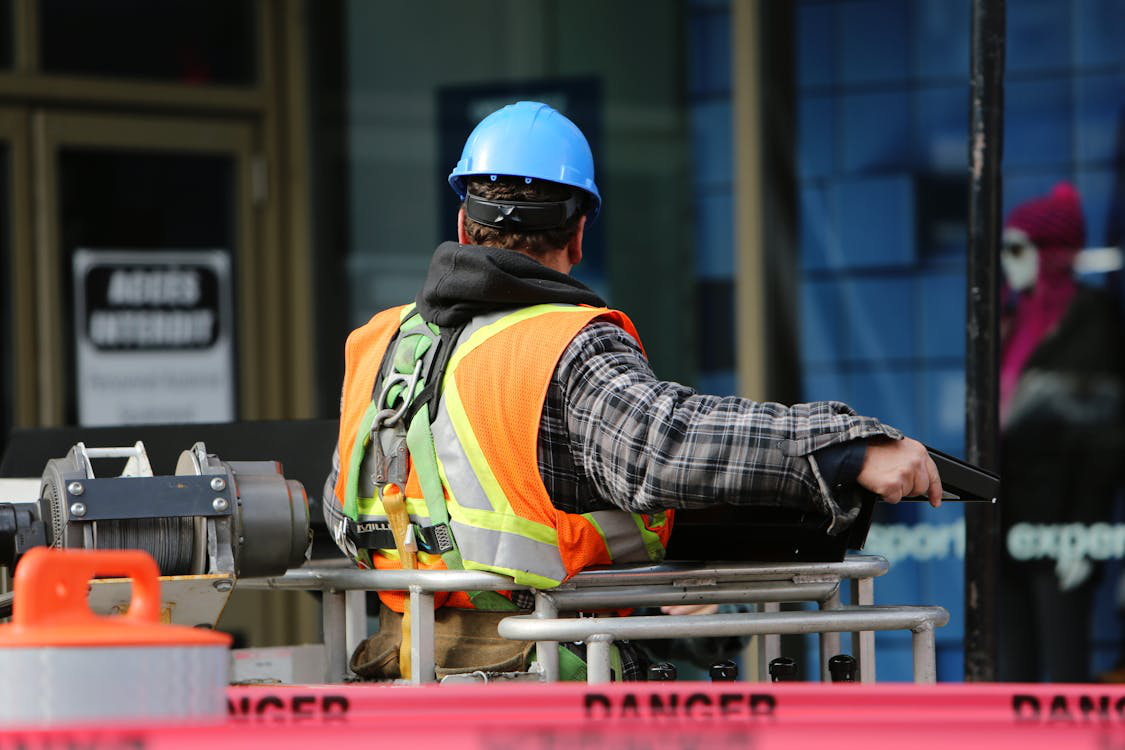 A worker in PPE near heavy machinery