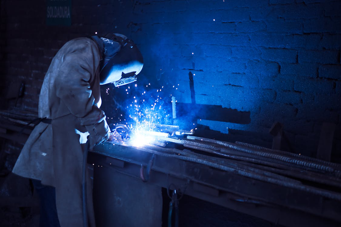 A man wearing protective PPE in a heated work environment