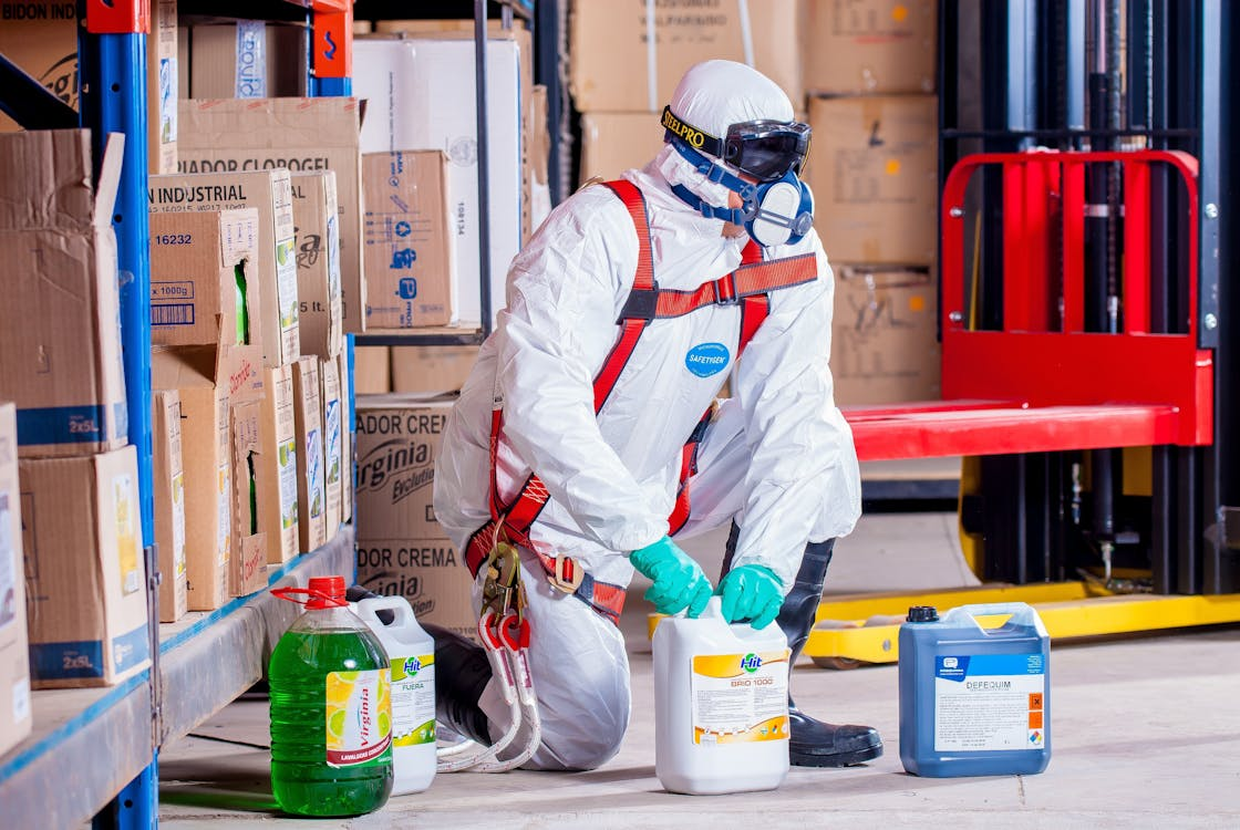 Person wearing personal protective equipment (PPE) and working safely with hazardous chemicals.